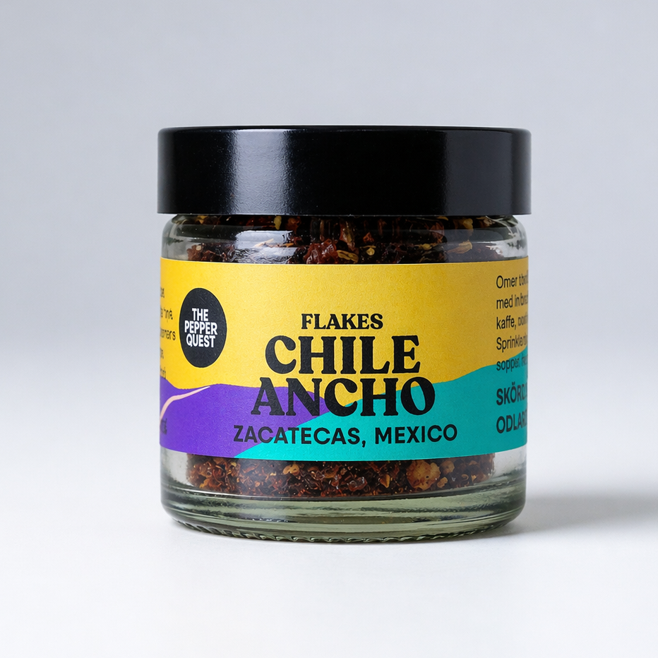 Jar of Chile Ancho flakes with colorful label on a white background