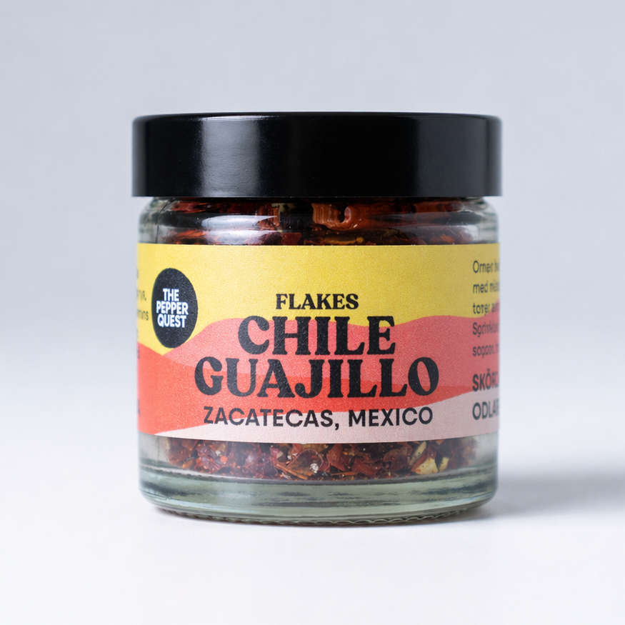 Jar of Chile Guajillo flakes with a colorful label on a white background