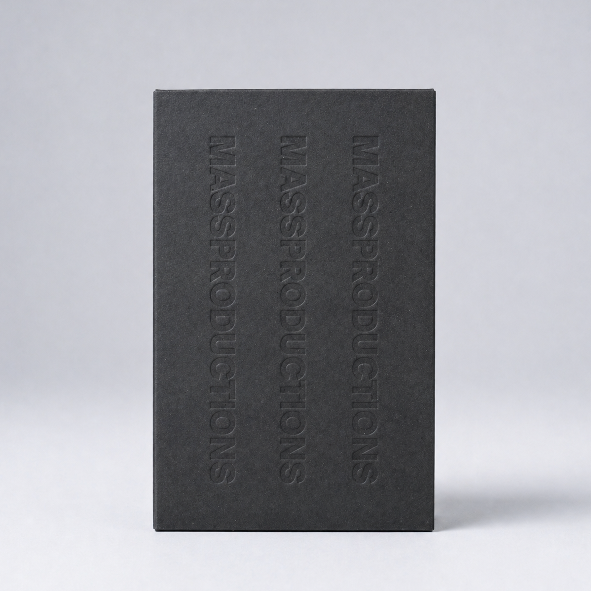 Black book with 'MASSPRODUCTIONS' embossed on the cover against a light gray background