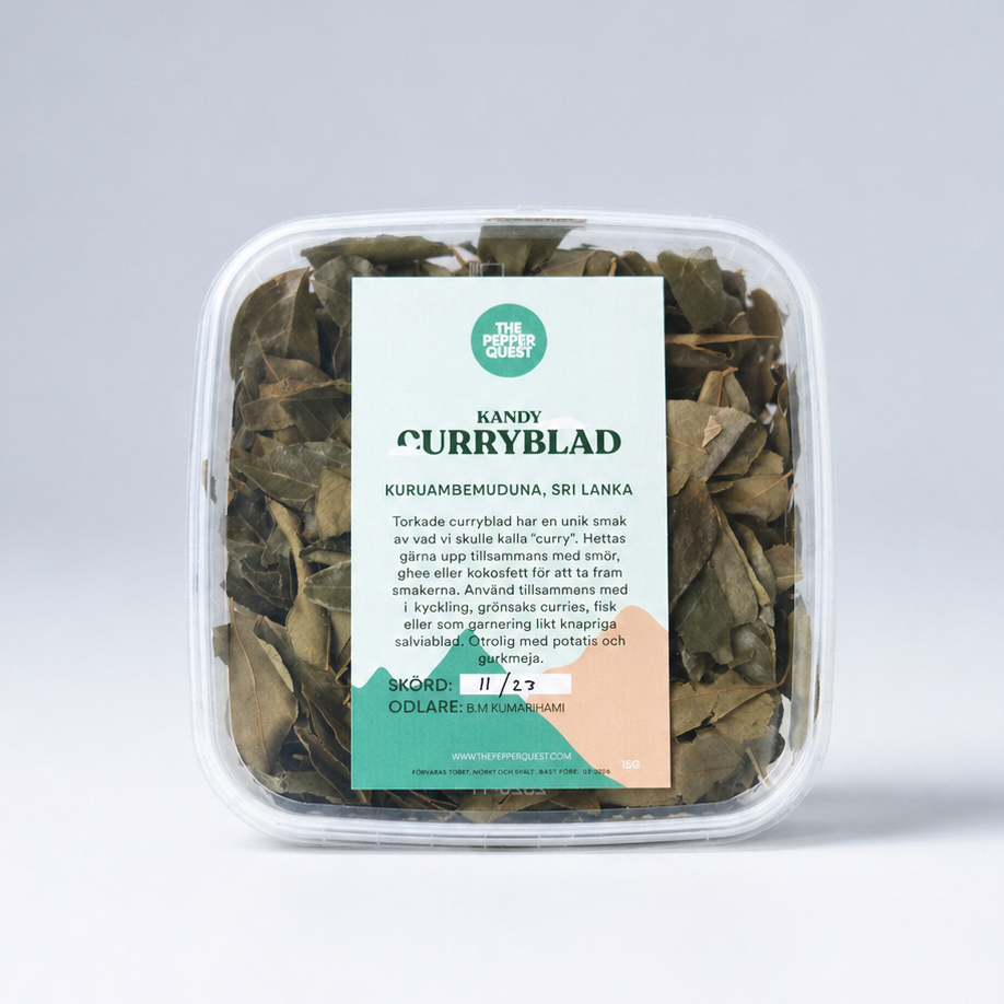 Container of curry leaves with a label on a light gray background